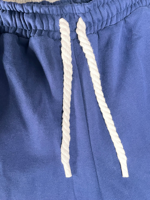 Close-up of blue fabric with white drawstrings on a blue background